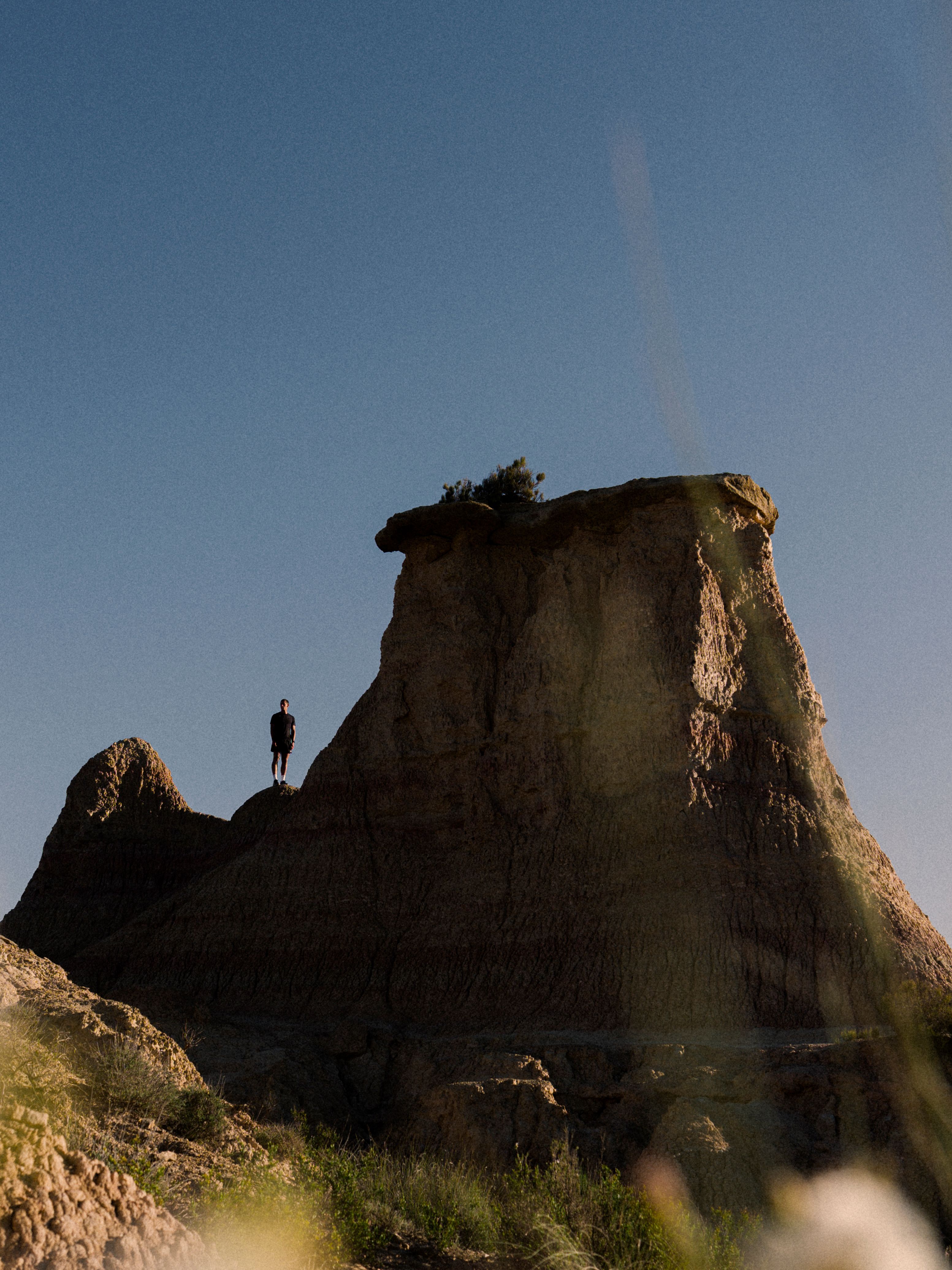 A person standing on top of a rock formation against a blue sky