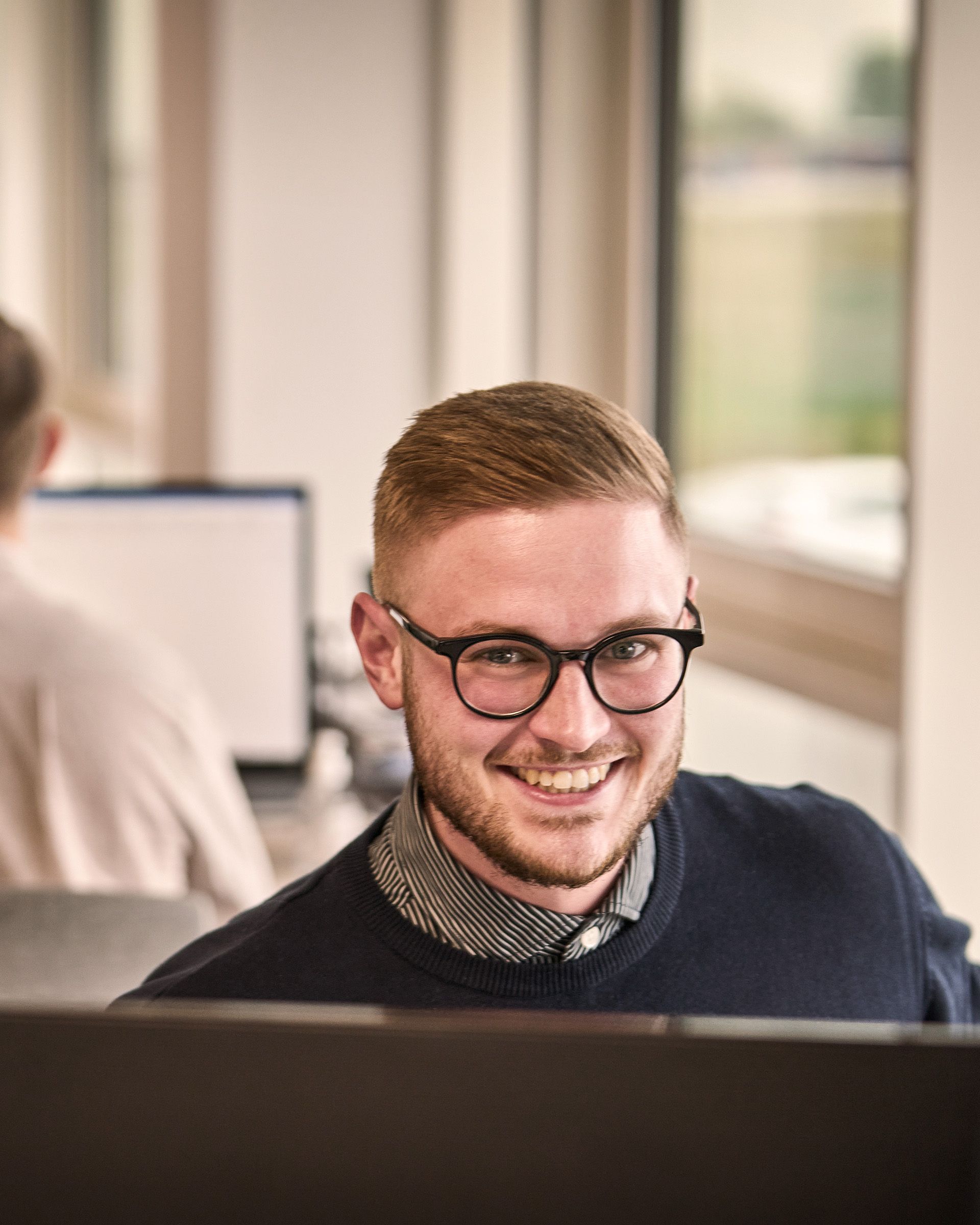 A STARTEX colleague smiling at his desk